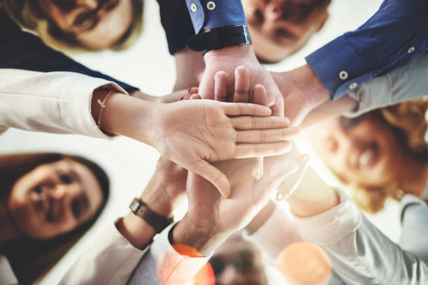 Cropped shot of a group of businesspeople putting their hands together in a huddle