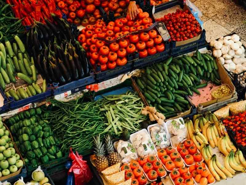 Variety of fruits and vegetables arranged in crates at a market stall.