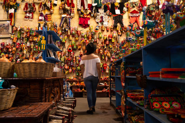 woman observing hand-painted colored masks - craft market in Antigua Guatemala