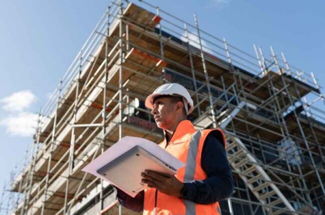 Construction engineer reviewing plans at an urban development site