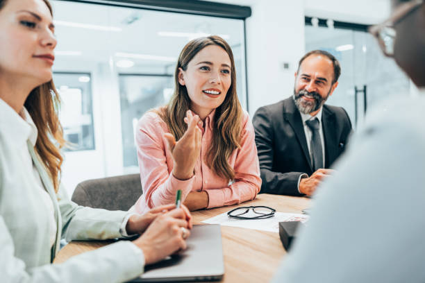 Modern business team discussing new ideas at the office. Business people on meeting in modern office. Colleagues smiling and talking at board room. Brainstorming