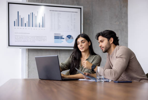 Business team working together at the office using a laptop computer while preparing a presentation