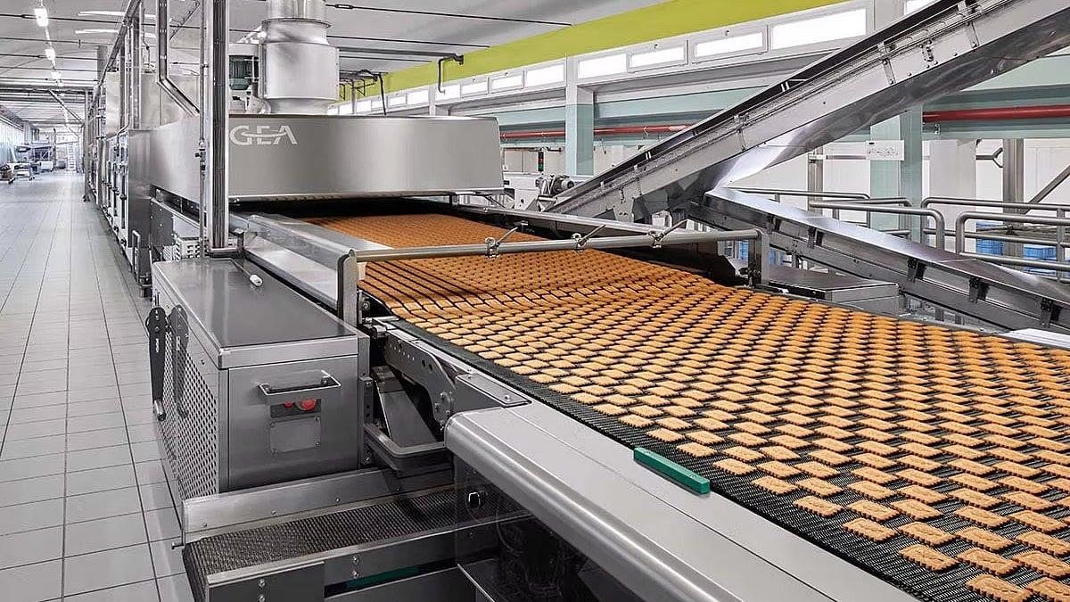 Automated biscuit production line with industrial machinery and conveyor belts used to manufacture food products.